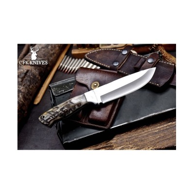 Handmade sheep horn bushcraft knife with leather sheath on wood background